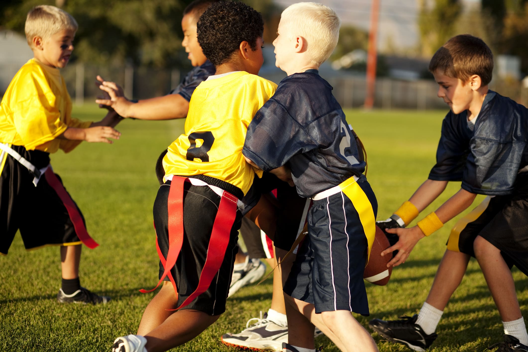 Young boys play flag football.